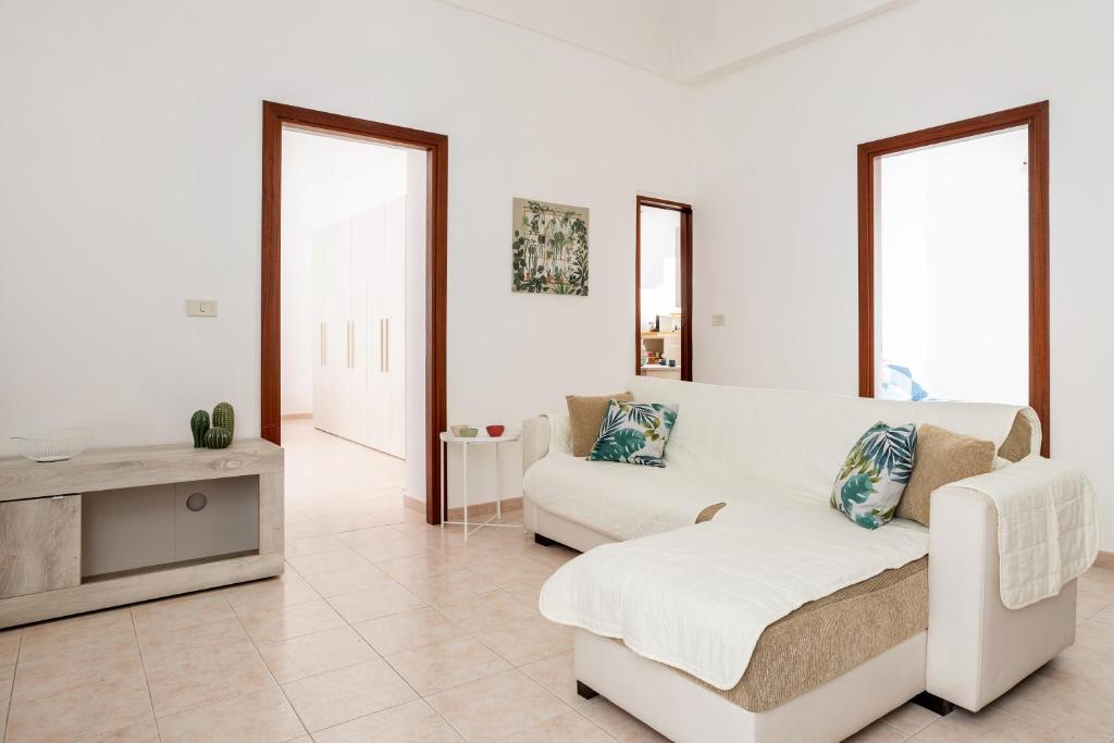 a white living room with a couch and a table at Chez Dione in Siracusa