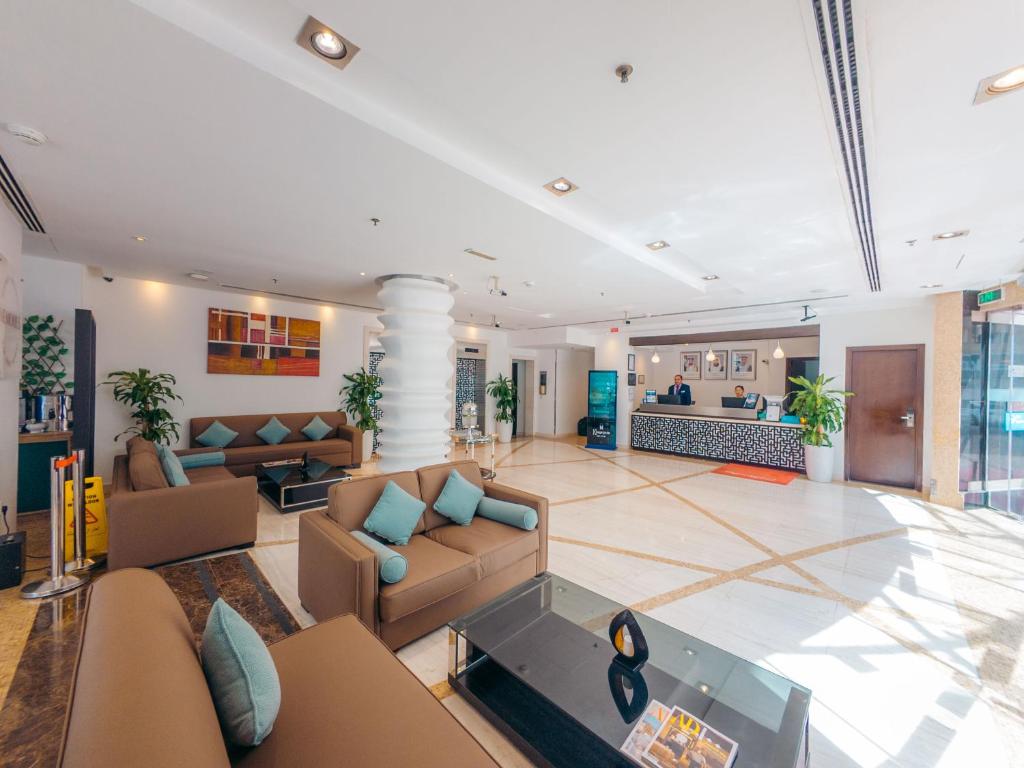 a lobby with couches and a glass table at Kingsgate Hotel by Millennium in Abu Dhabi