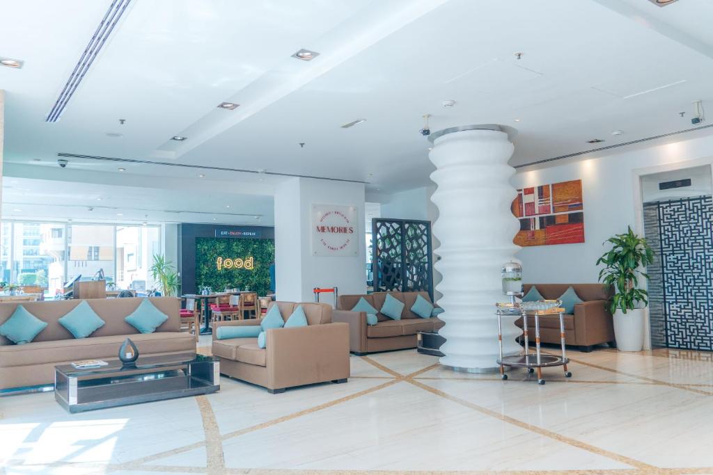 a lobby with couches and tables in a building at Kingsgate Hotel by Millennium in Abu Dhabi