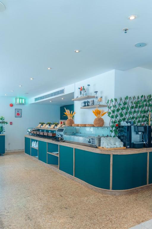 a kitchen with blue cabinets and a counter top at Kingsgate Hotel by Millennium in Abu Dhabi