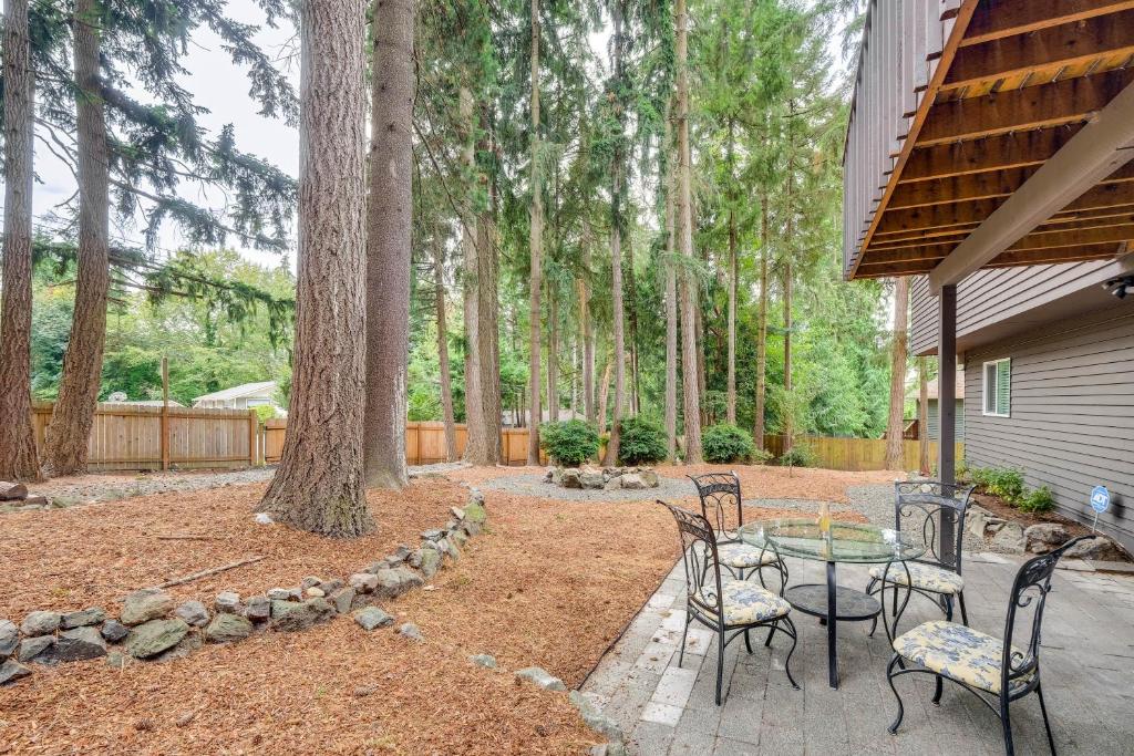 a patio with a table and chairs and trees at Bremerton Home with Fire Pit Near Parks and Museums in Bremerton