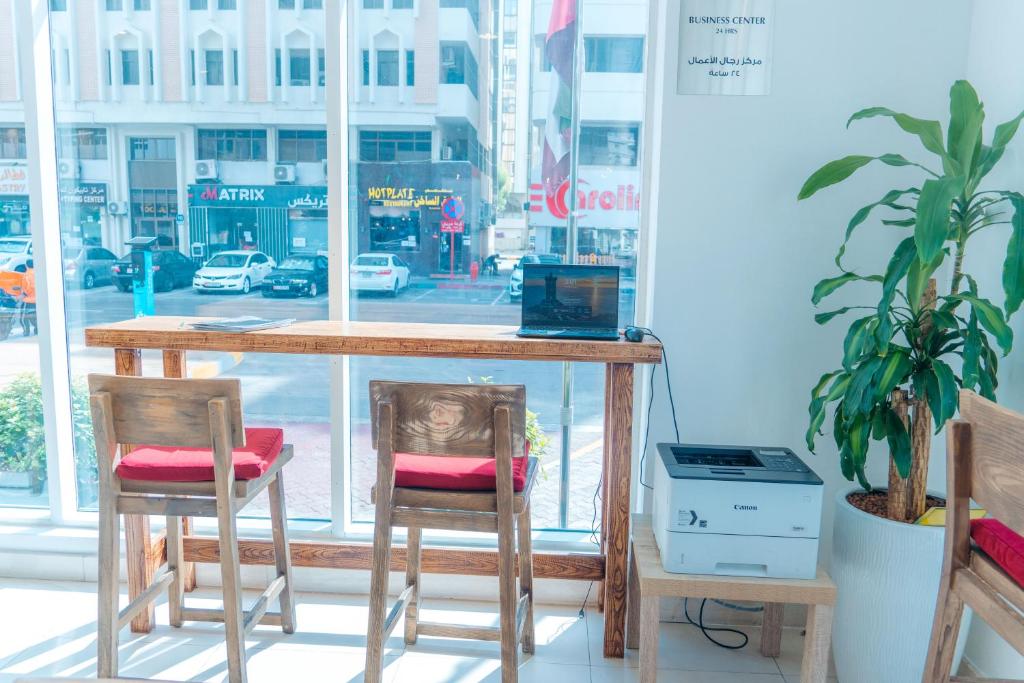 a table with two chairs in front of a window at Kingsgate Hotel by Millennium in Abu Dhabi
