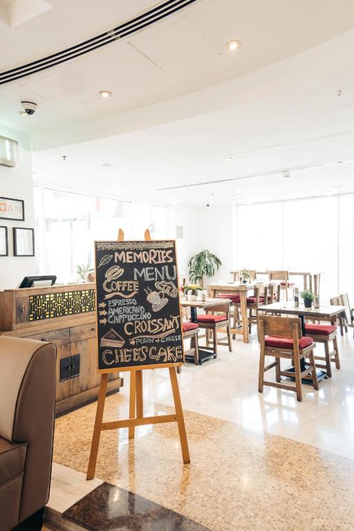 a restaurant with a sign in the middle of a room at Kingsgate Hotel by Millennium in Abu Dhabi