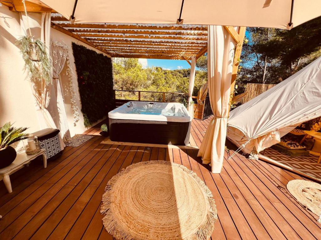 a wooden deck with a hot tub in the middle at LOVE ROOM Tente Lodge spa MFG chez C&C, exclusivement réservée aux ADULTES in Cantaron