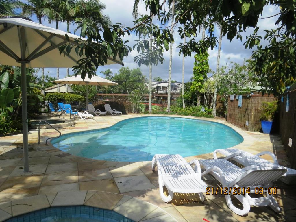 a large swimming pool with a lounger in a yard at Noosa Keys Resort in Noosaville