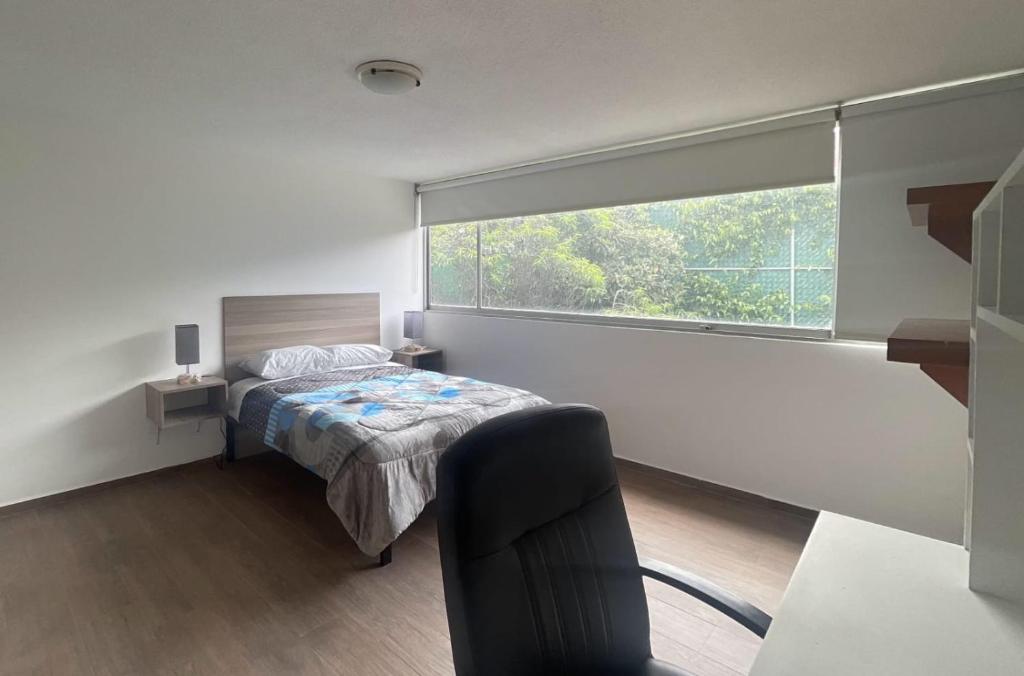Un dormitorio con una cama y una ventana grande en Casa Monasterios, en Ciudad de México