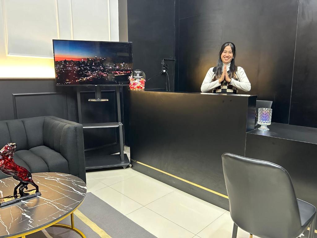 a woman standing behind a counter in a room at Cozy Furnished Studio Apartemen Transpark Cibubur by Royal Home Indonesia in Kalimanggis