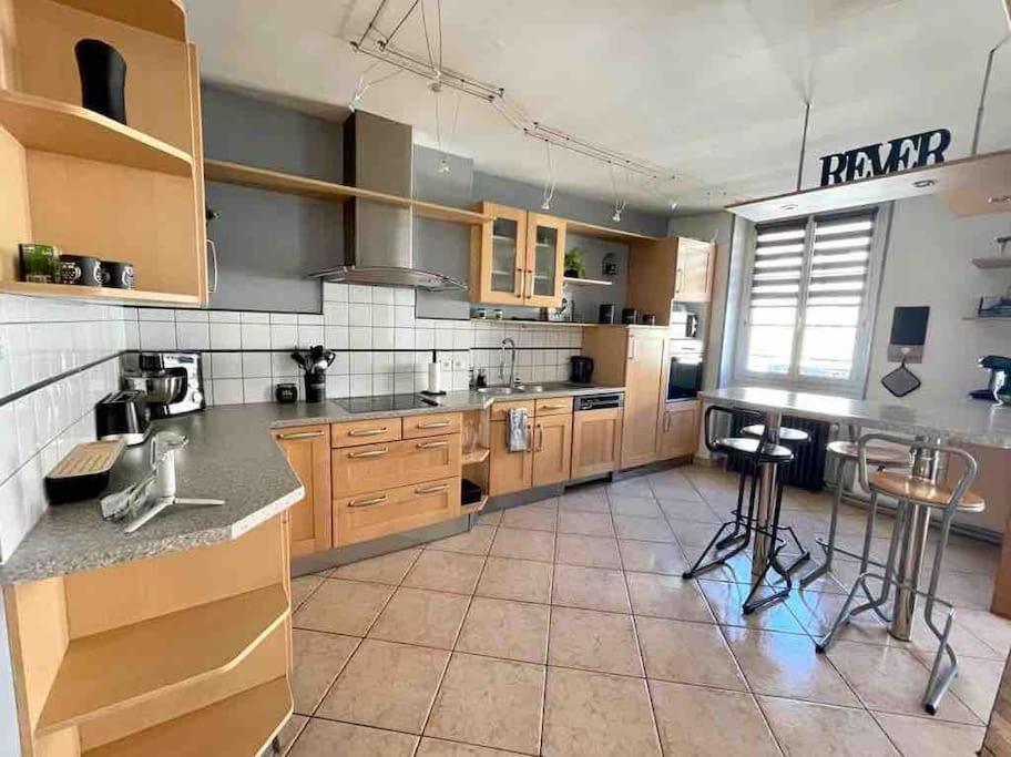 a large kitchen with wooden cabinets and counter tops at Grand appartement centre ville in Le Creusot