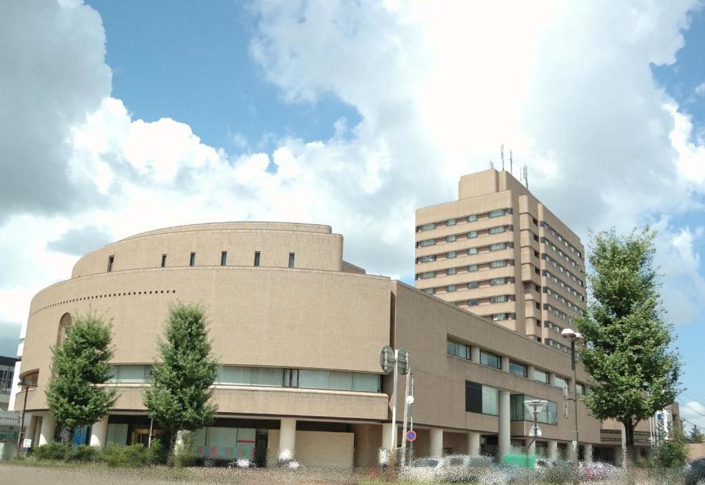 um grande edifício com um edifício alto ao fundo em Hotel New Otani Nagaoka em Nagaoka