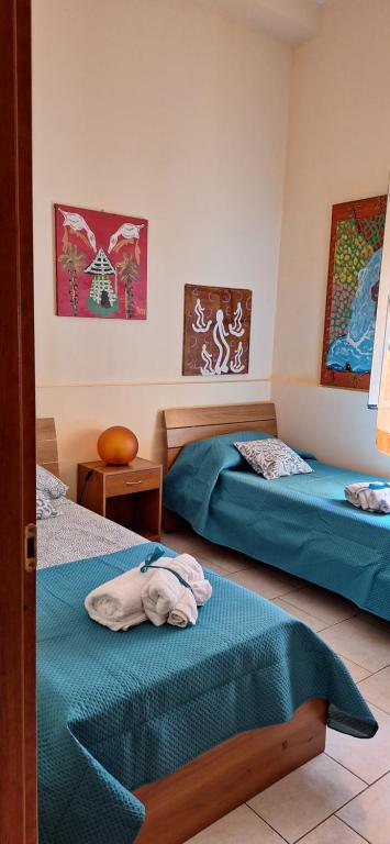 sypialnia z 2 łóżkami i ręcznikami na podłodze w obiekcie Apartment Inn w mieście Aci Castello