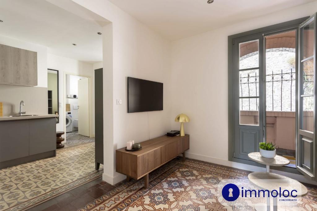 un salon avec une télévision sur un mur dans l'établissement Air-conditioned studio near Monaco, à Beausoleil