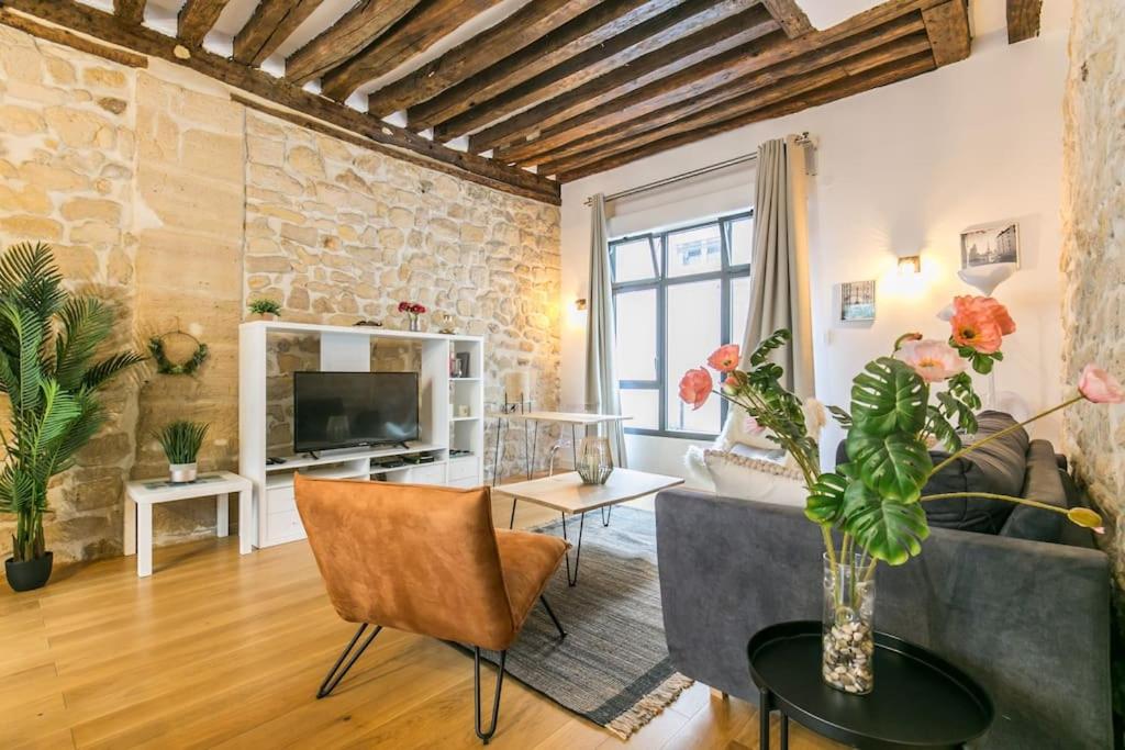 un salon avec un canapé et une télévision dans l'établissement Cœur de Voltaire - Loft cosy Parisien, à Paris