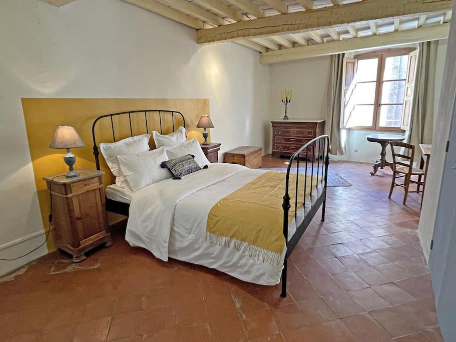 une chambre avec un grand lit et une table dans l'établissement Maison Loumio - Charming 4 double bedrooms village home -ultra fast wifi, à Aups
