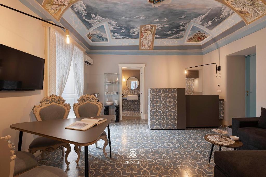 un soggiorno con tavolo e soffitto di Le Dimore dei Principi a Catania