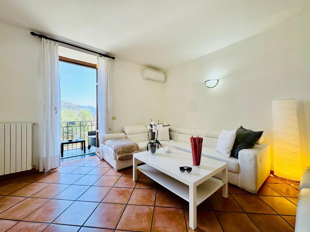 a living room with a white couch and a table at YourHome - Casa Carmela in Colli di Fontanelle