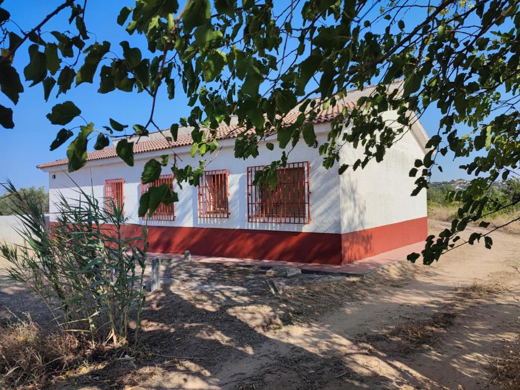 a house with a red and white stripe at Casa la Poveda in Villa del Prado