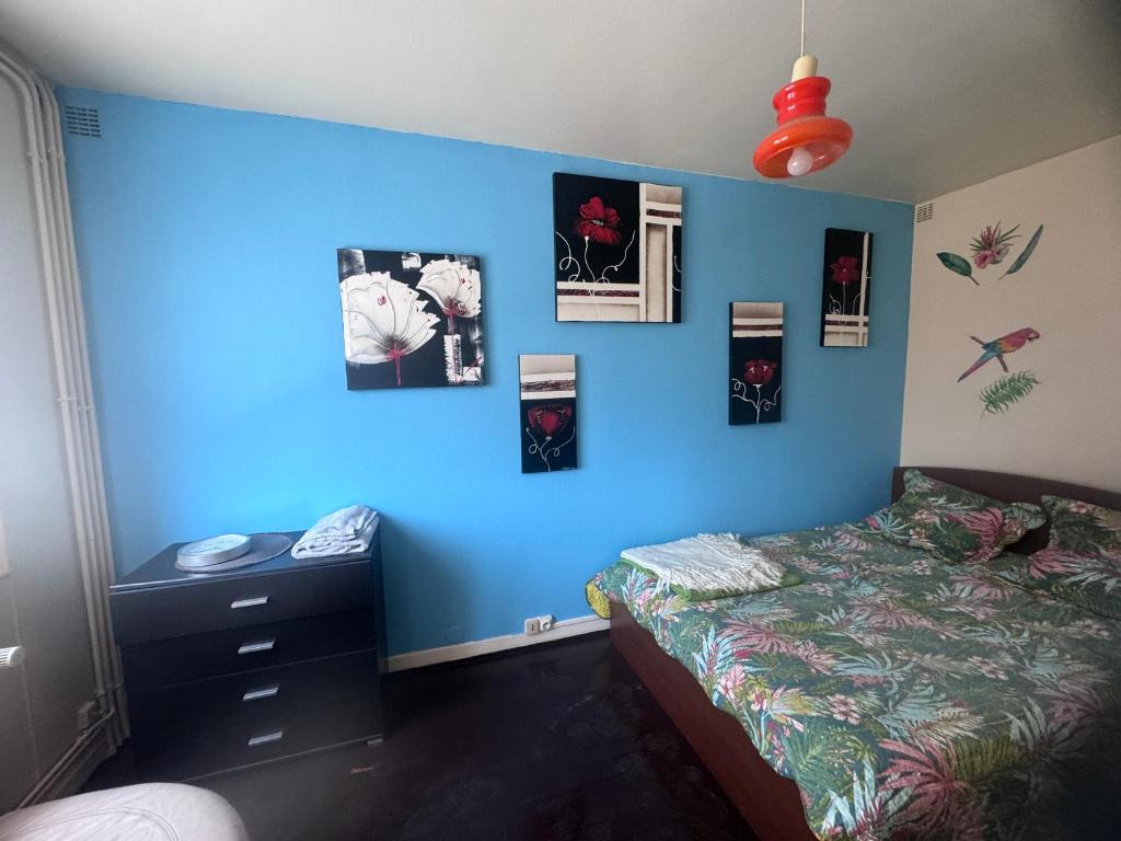 - une chambre bleue avec un lit et un mur bleu dans l'établissement Studio à louer, à Villard-Bonnot