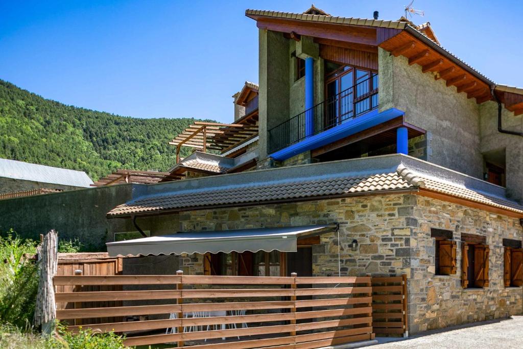 a building with a balcony and stairs in front of it at El Escondite de Biescas in Biescas