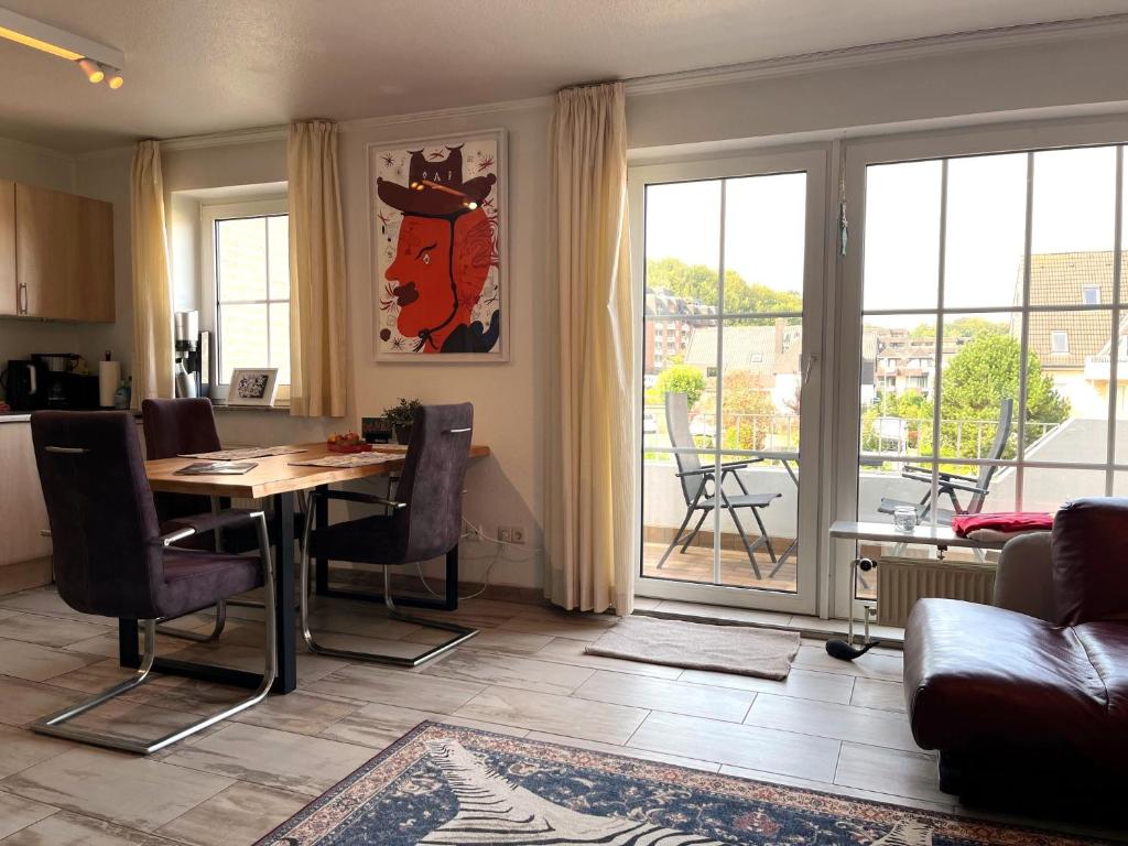 una cucina e un soggiorno con tavolo e sedie di fewo1846 - Wellenrauschen - strandnahes Apartment mit Balkon und Meerblick a Harrislee