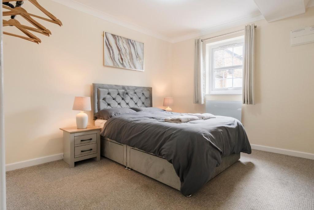 a bedroom with a bed and a nightstand and a window at Ely Stays Flat 1 Stylish City Centre Apartment in Ely