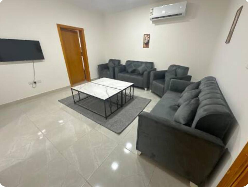 a living room with a couch and a table at نجوم السعد 7 in Al Masfalah