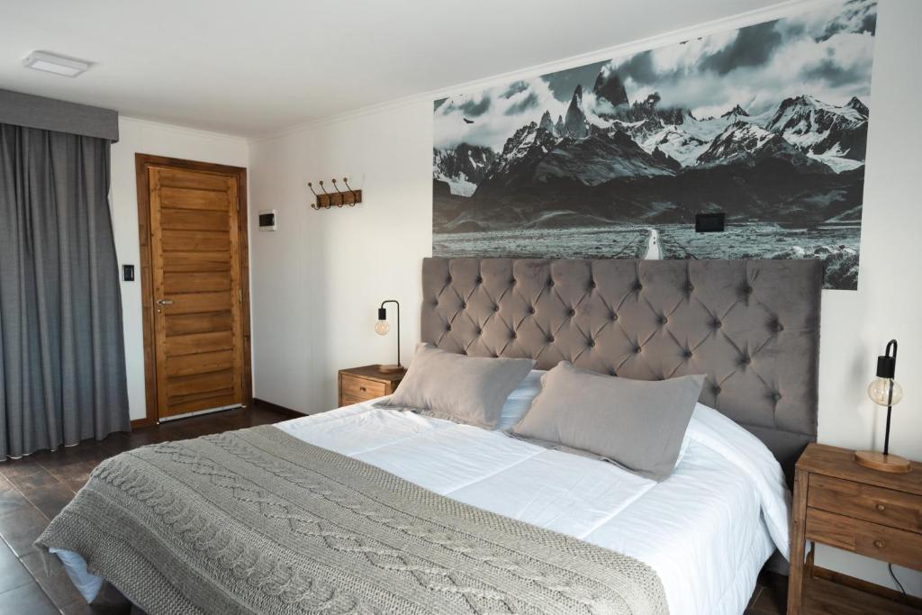 a bedroom with a large bed with a painting on the wall at Patagonia Hope Suites in El Calafate