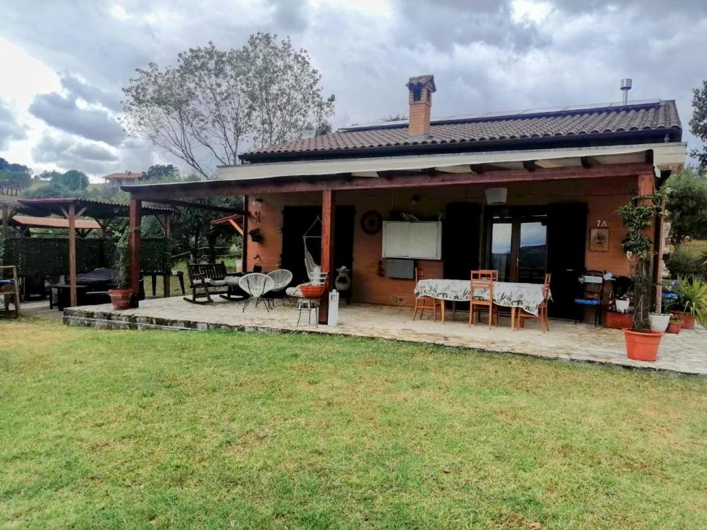 a house with a patio and a yard at Casa degli Ulivi in Tolentino
