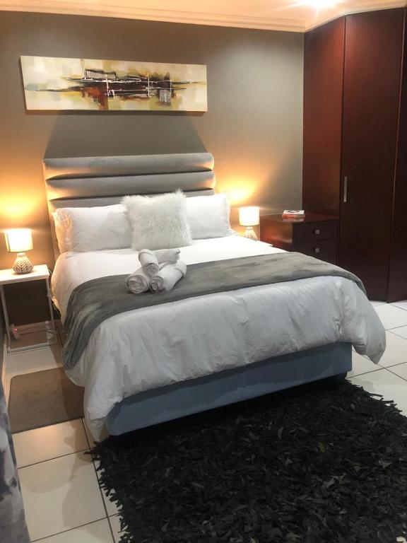 a bedroom with a large bed with two stuffed animals on it at Cass Villa 25 Kimberley in Kimberley