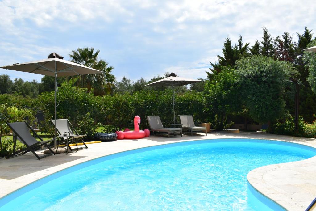 a swimming pool with chairs and an inflatableishyishy at Apeiron Villas - Olive Forest Apartment in Kefallonia