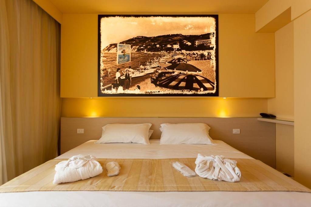 una camera da letto con un letto e due asciugamani di Hotel Resort Marinella a Gabicce Mare