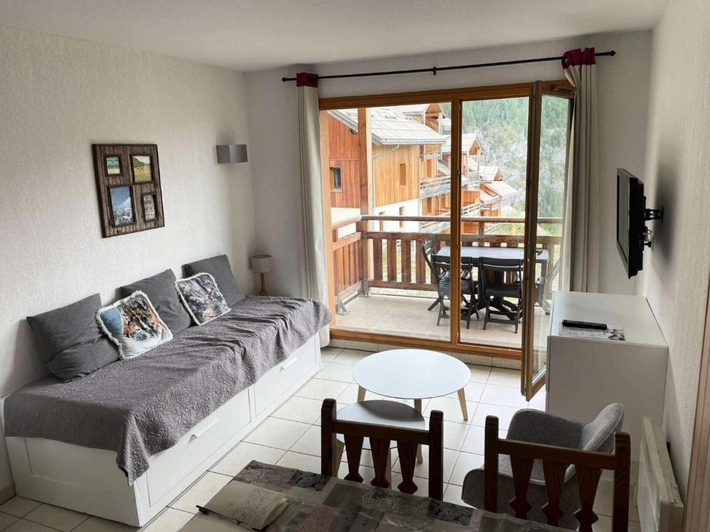 d'un salon avec un canapé et un balcon. dans l'établissement Résidence Balcon Des Airelles - N°511 balcon des Airelles MAE-6674, aux Orres