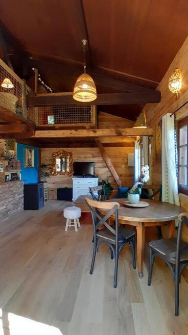 un salon avec une table et des chaises en bois dans l'établissement Petit chalet authentique, à La Blonnière