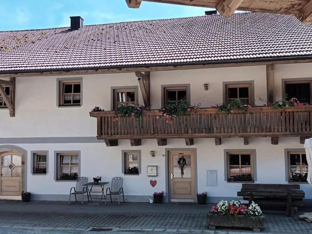 a building with a balcony and a table and chairs at Ferienwohnung im Bayerischen Wald mit Terrasse in Viechtach
