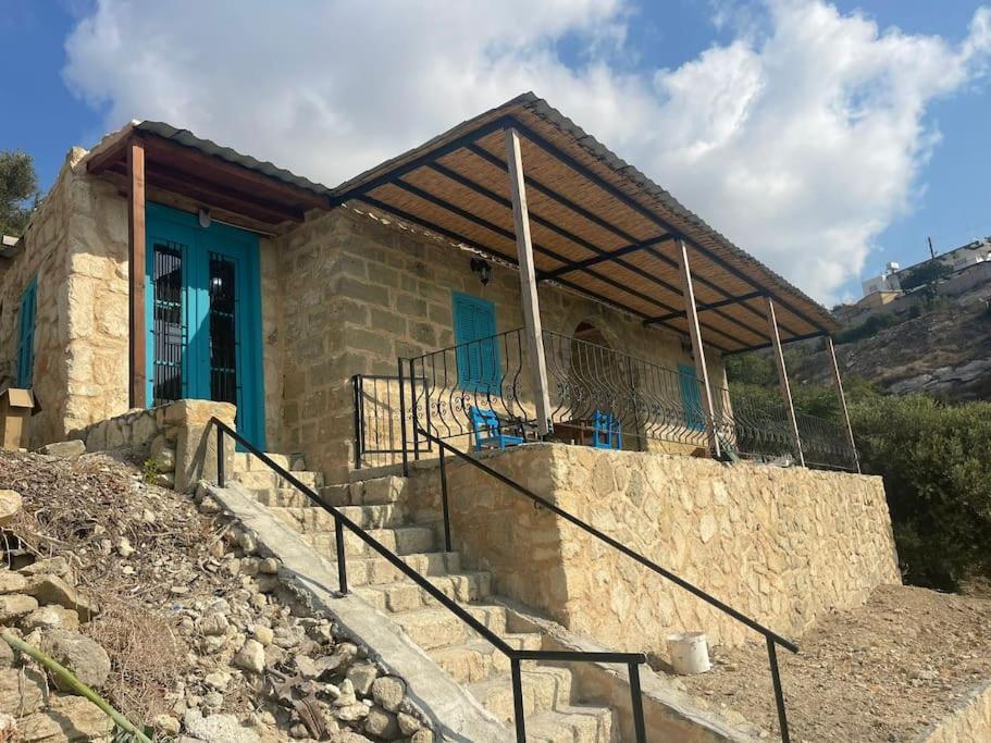 a house with a blue door and stairs in front at King's Hill Traditional House in Galinoporni