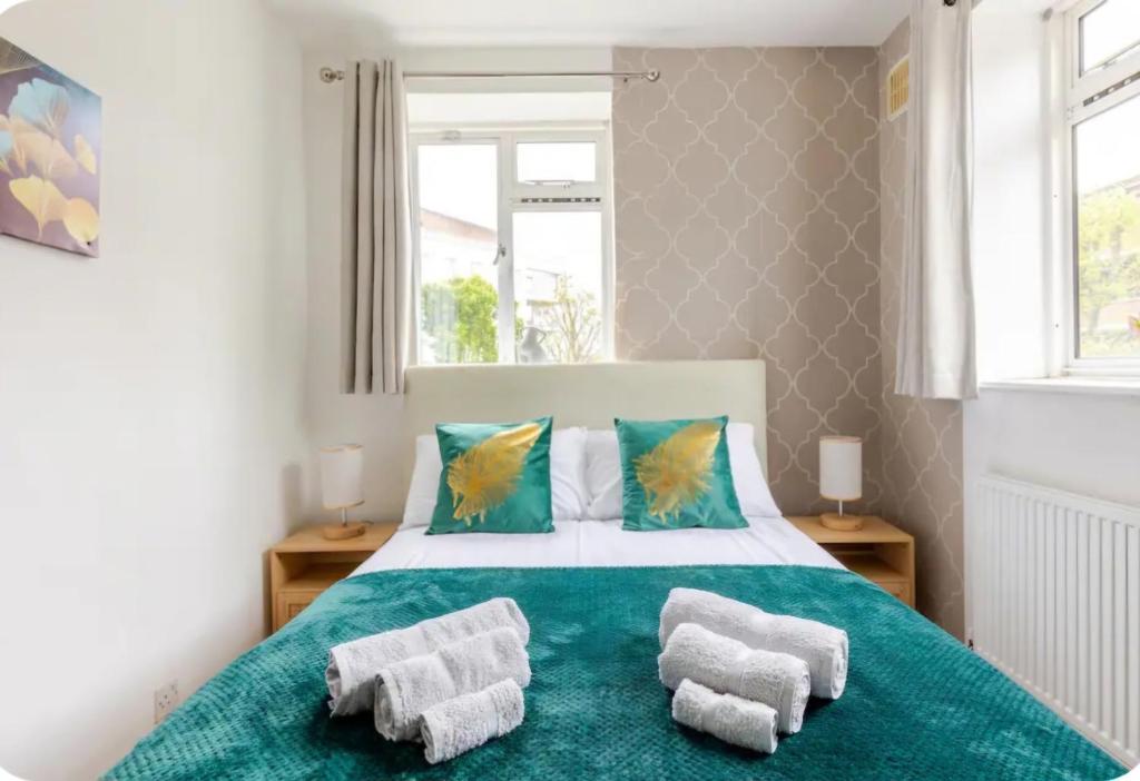 a bedroom with a bed with towels on it at Spacious Two Bedroom Apartment in Battersea, Free Parking in London