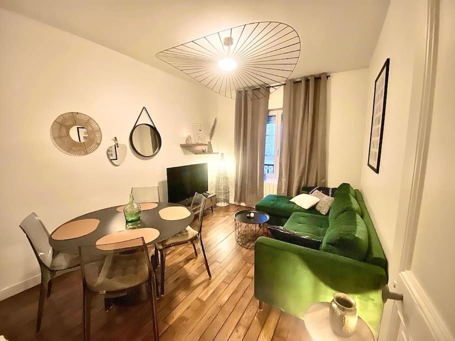 un salon avec un canapé vert et une table dans l'établissement Appart in Paris, à Pantin