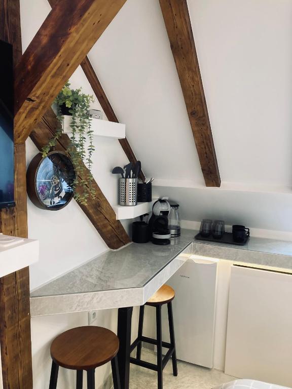 - une cuisine avec un comptoir et deux tabourets dans une pièce dans l'établissement Petit nid sympa a Strasbourg, à Strasbourg