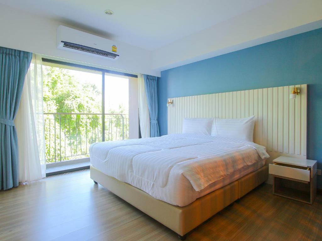sypialnia z dużym łóżkiem i dużym oknem w obiekcie Huahin City View w mieście Hua Hin