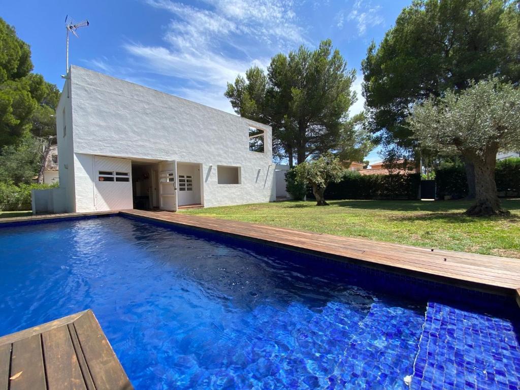 a large blue swimming pool in front of a house at Xalet Argany in Sant Jordi d'Alfama in Les tres Cales