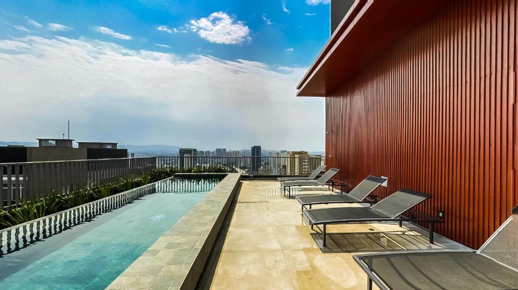 a balcony with chairs and a swimming pool on a building at 360 VN Turiassú by Housi in Sao Paulo