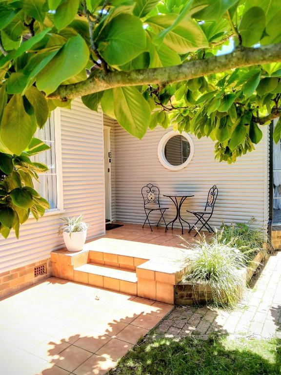 a patio with a table and benches on a house at Magnolia Corner in Bowral
