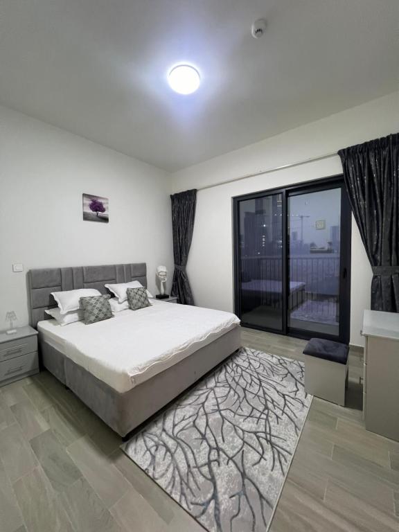 a bedroom with a bed and a large window at Comfort Zone in Sharjah