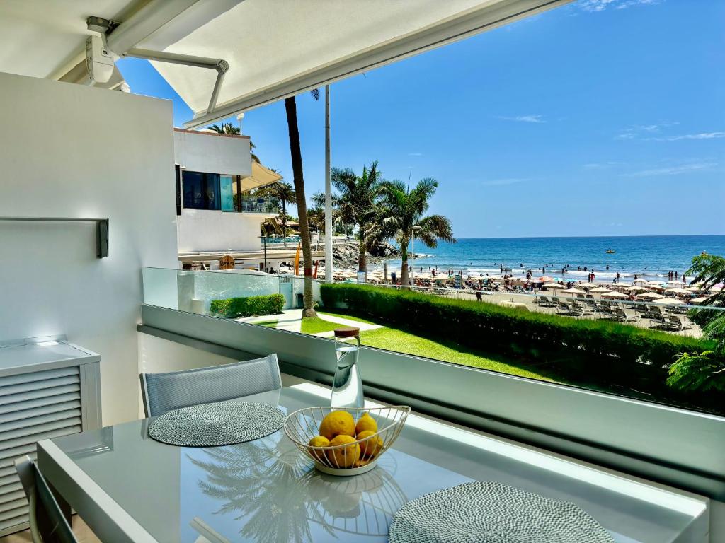 Ein Tisch mit einer Obstschale auf einem Balkon mit Blick auf den Strand in der Unterkunft Las Nasas, Vistas al Mar, 2 dormitorios in San Agustín