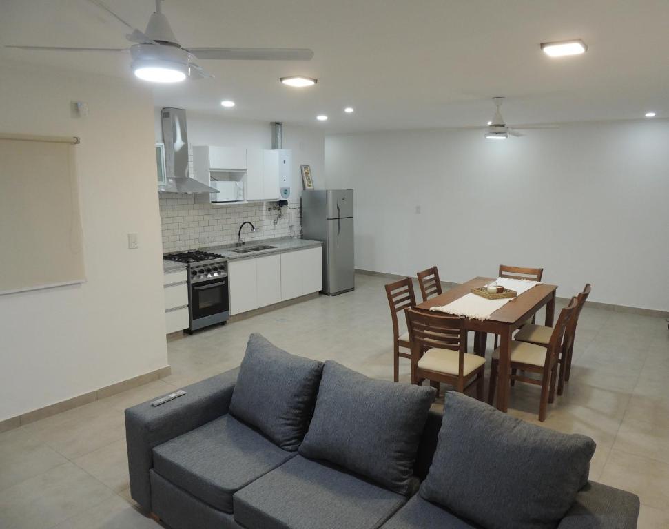 a living room with a couch and a table and a kitchen at El Refugio de Salvador in Paraná