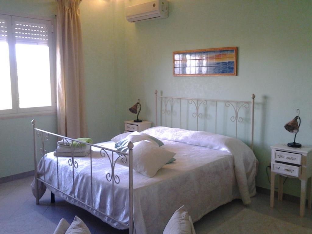 a bedroom with a white bed and a window at Dai Siciliani Paolo e Paola in Marsala