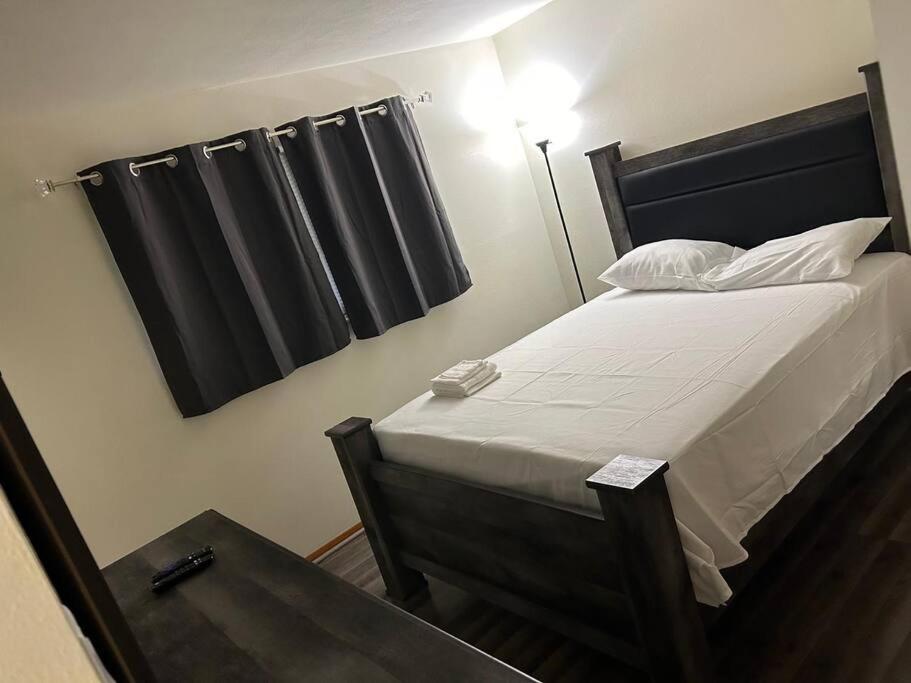 a bedroom with a bed with a black headboard and a table at Beautiful smart house for stays in Larimore