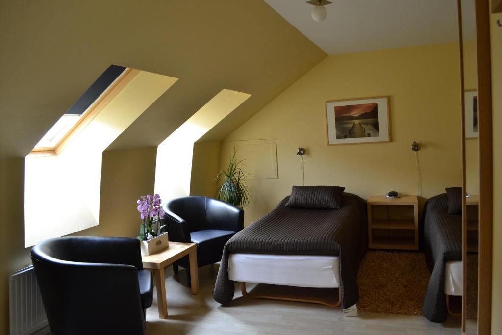 1 Schlafzimmer mit einem Bett, 2 Stühlen und einem Fenster in der Unterkunft Hotell City in Hässleholm