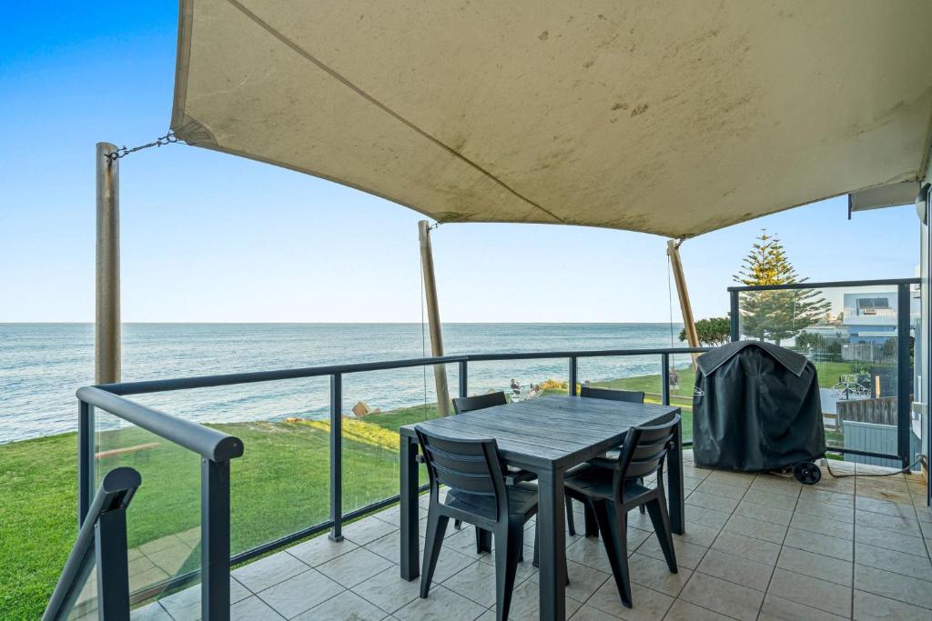 a table and chairs on a balcony overlooking the ocean at Seaside Haven on Hutton Road in The Entrance