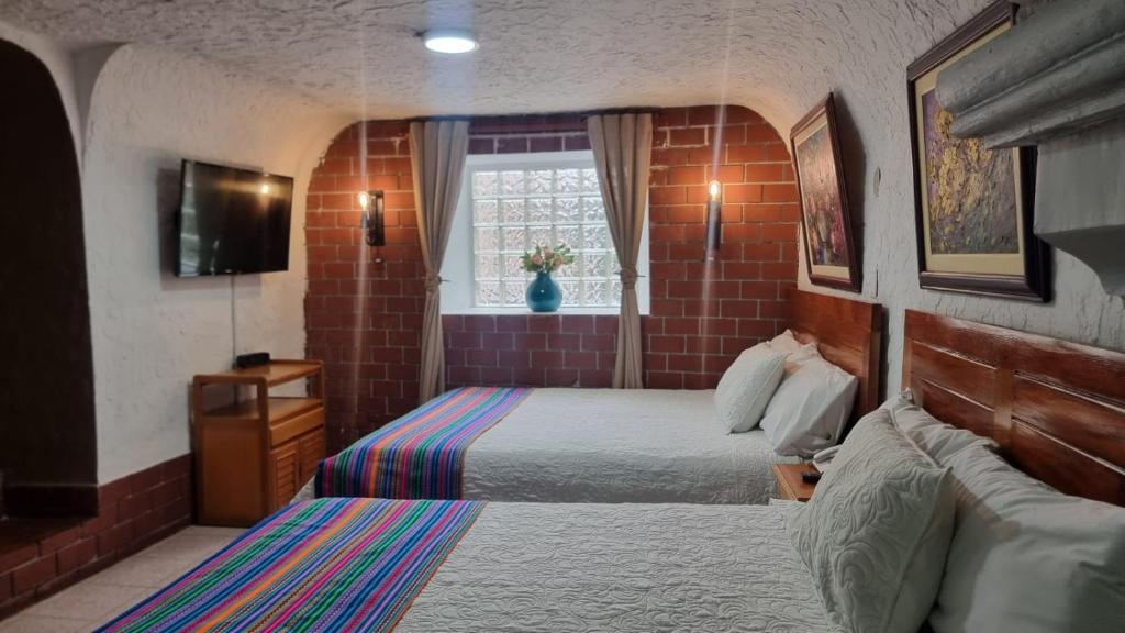 a bedroom with a bed and a couch and a window at Hatuchay Inka Apart Hotel in Cajamarca
