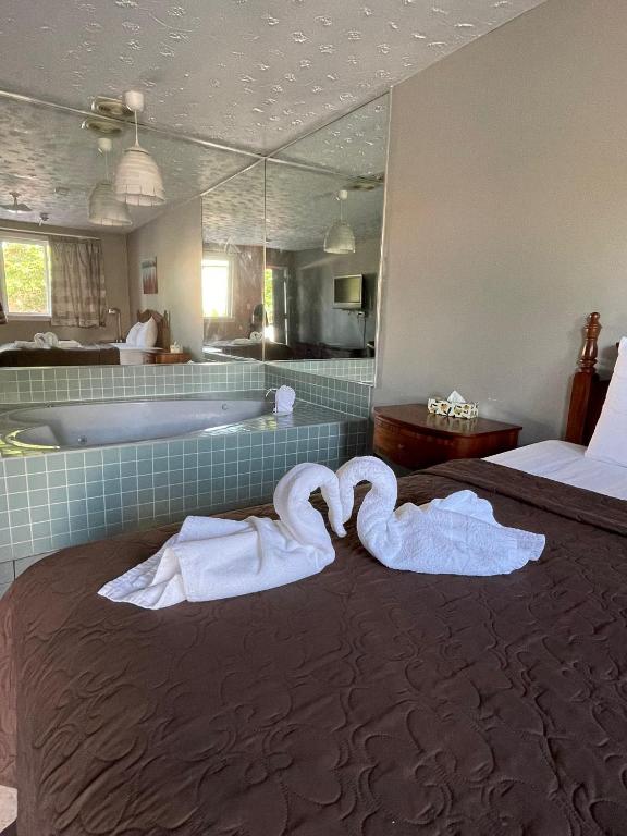 two swans towels on a bed in a bathroom at 6267 Persepolis Inn in Niagara Falls